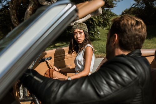 Free A couple having an intense conversation while seated in a convertible car outdoors. Stock Photo