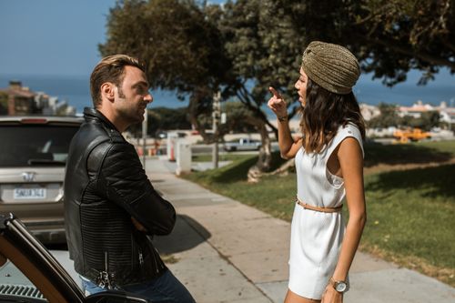 Free An interracial couple having an intense conversation near a park with an ocean view, expressing emotions vividly. Stock Photo