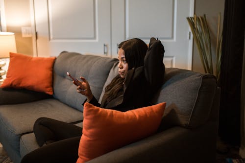 Free Woman in Black Blazer and Black Pants Sitting on a Couch  Stock Photo