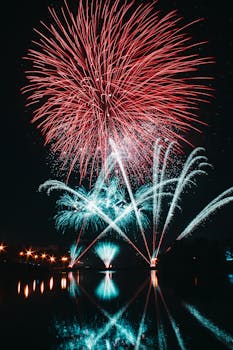 夜空中，充满活力的烟花照亮了宁静的湖面