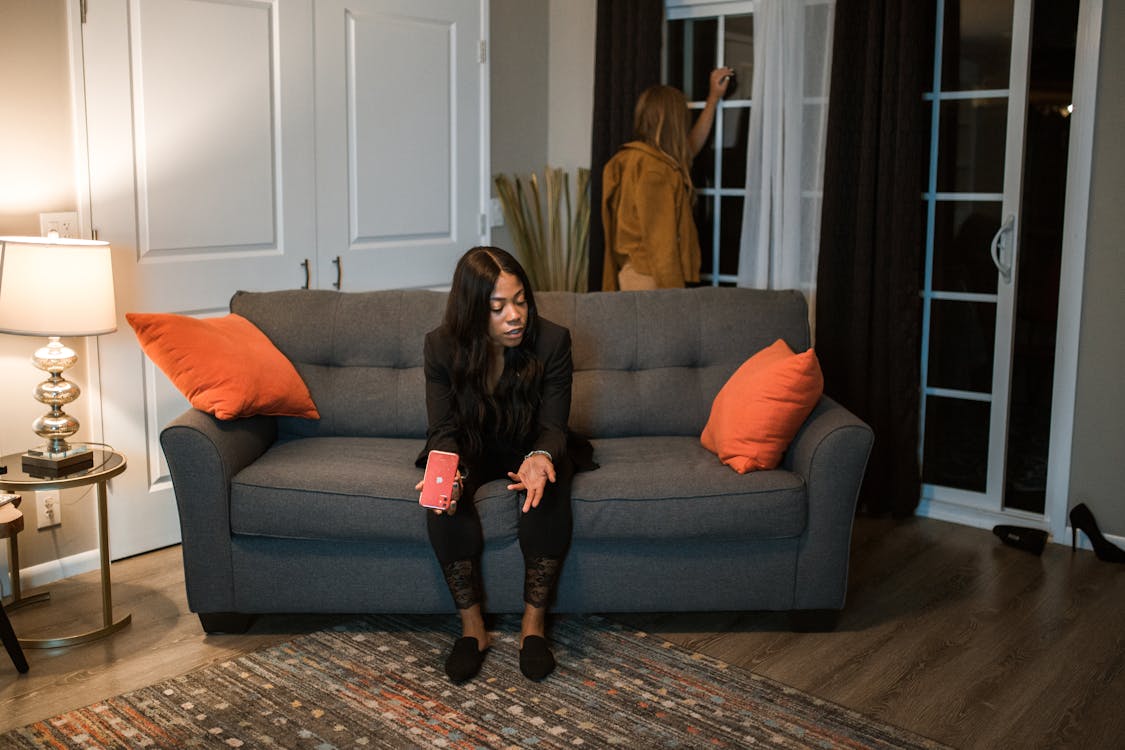 Free Woman in Black Blazer Sitting on Gray Couch Stock Photo