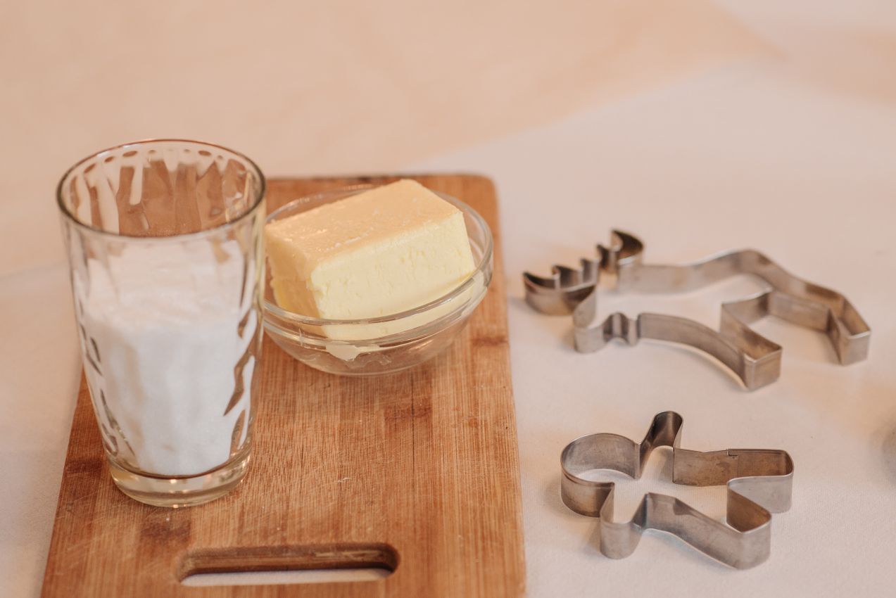 Butter in a bowl with milk and baking tools on a wooden board