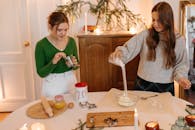 两名妇女在装饰着节日饰品的舒适厨房里准备节日饼干