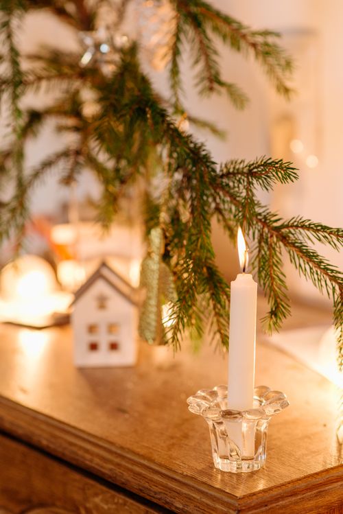 Free A cozy indoor setup with a lit candle, pine branches, and festive decor. Stock Photo