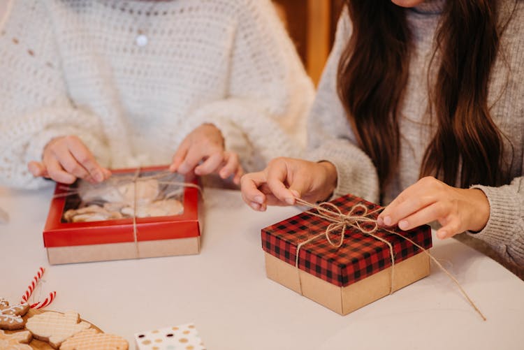 People Tying The Box Of Cookies