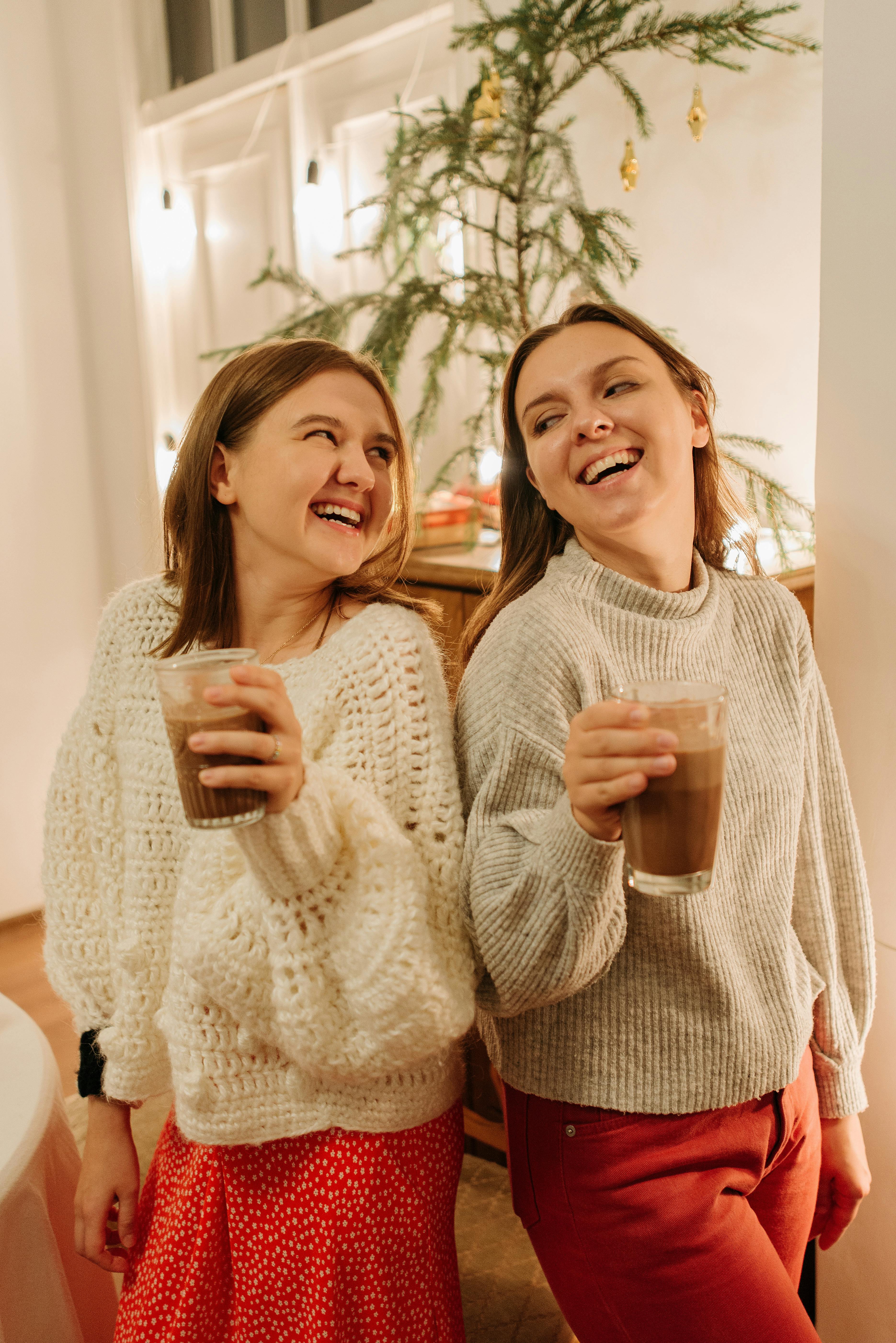 two young women smiling while holding delicious chocolate drinks