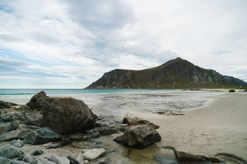 Free Tranquil empty coastline of turquoise ocean with mountains and rocky stone on shore Stock Photo