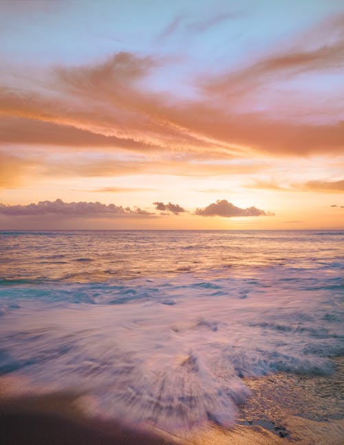 Gratis Gelombang Laut Menghantam Pantai Saat Matahari Terbenam Foto Stok