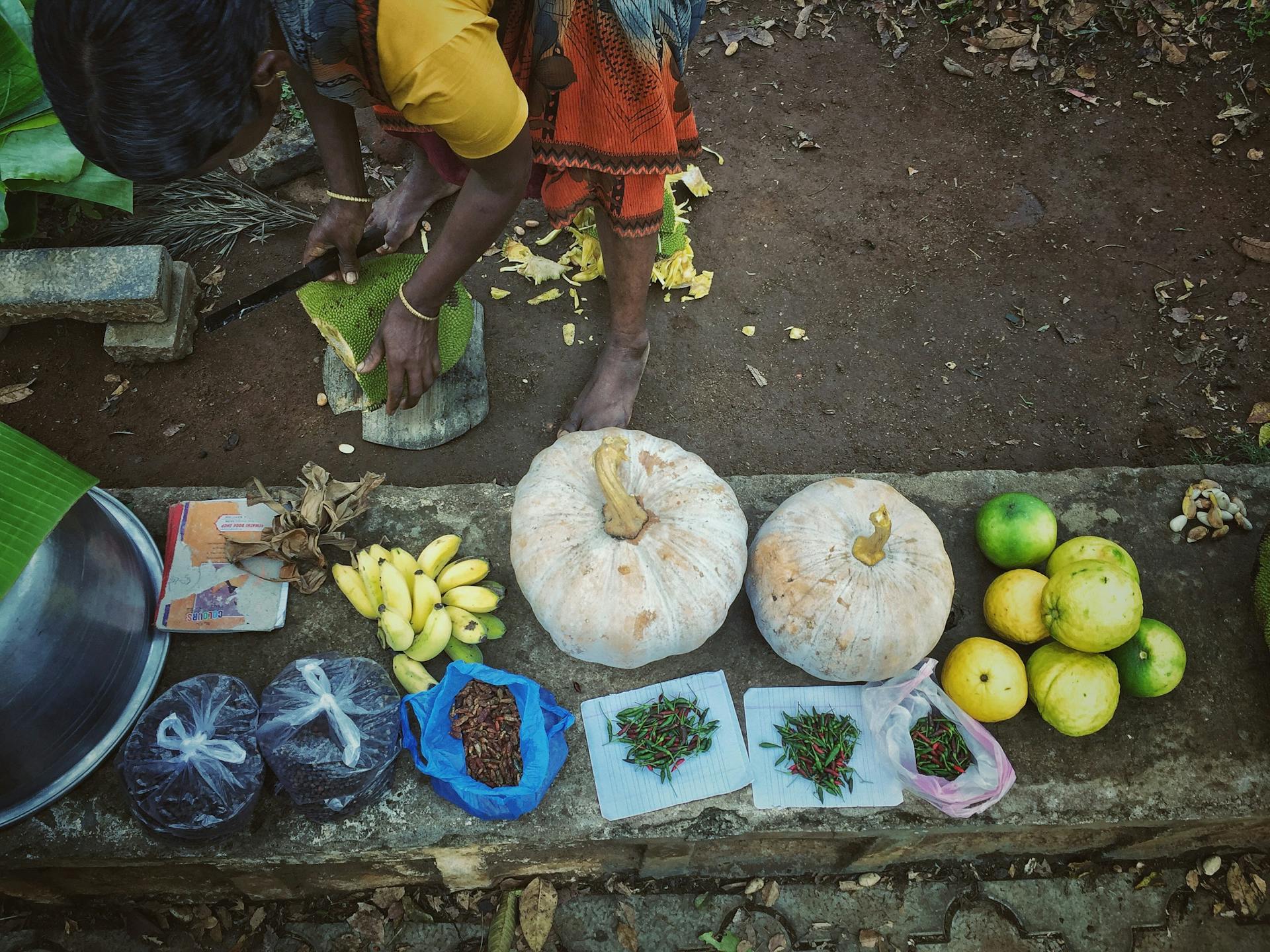 Photo capturing a vibrant market scene in Ariyurnadu, India with fresh produce and a vendor.