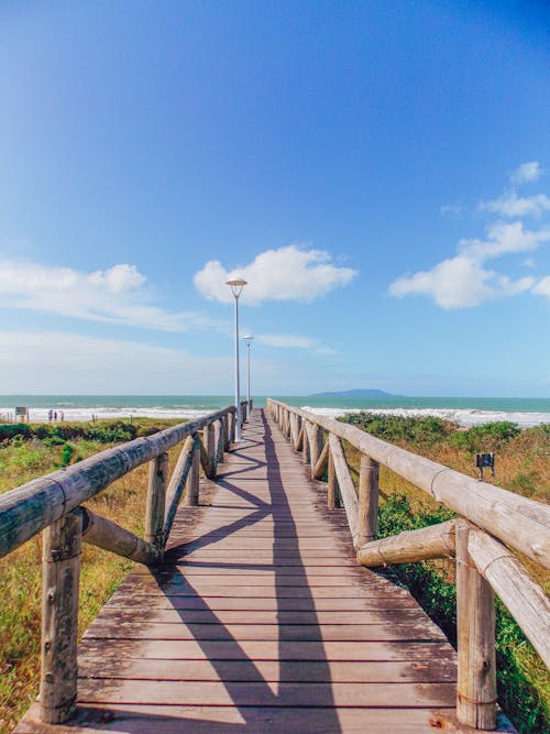 Wooden Bridge over Blue Sea Under Blue Sky