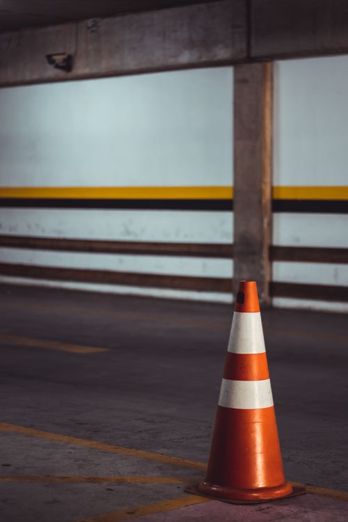 Free Orange traffic cone in an empty indoor parking area for safety. Stock Photo