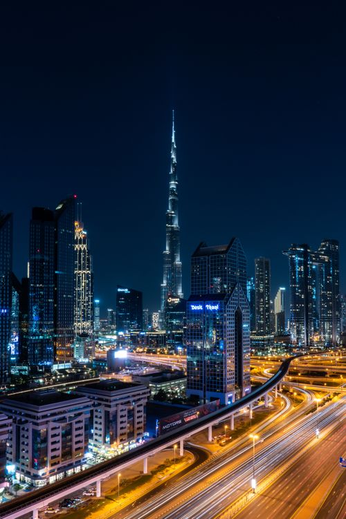Free A breathtaking aerial view of Dubai's skyline at night featuring the iconic Burj Khalifa. Stock Photo