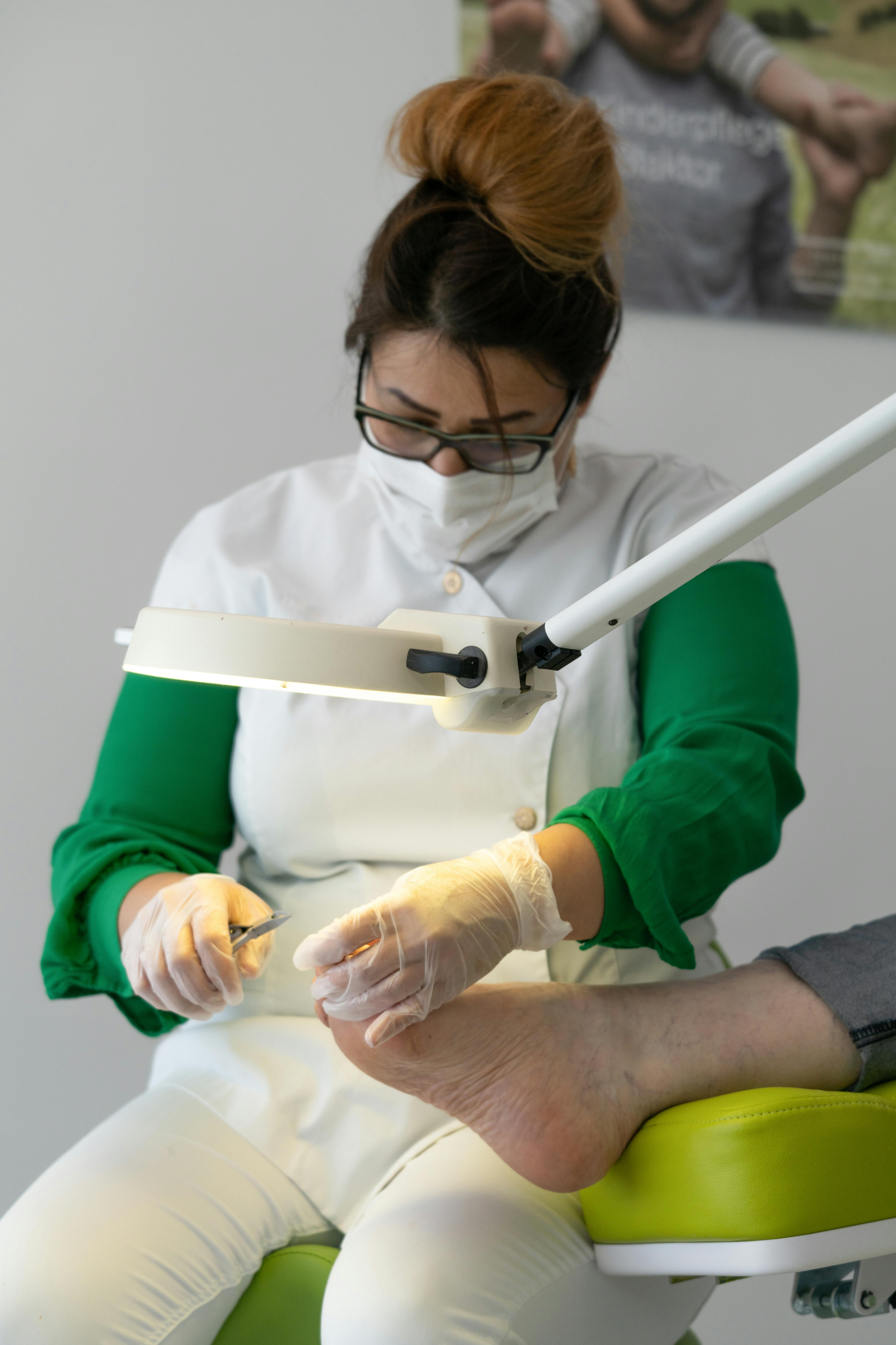 female nail technician worker with scissors treating client