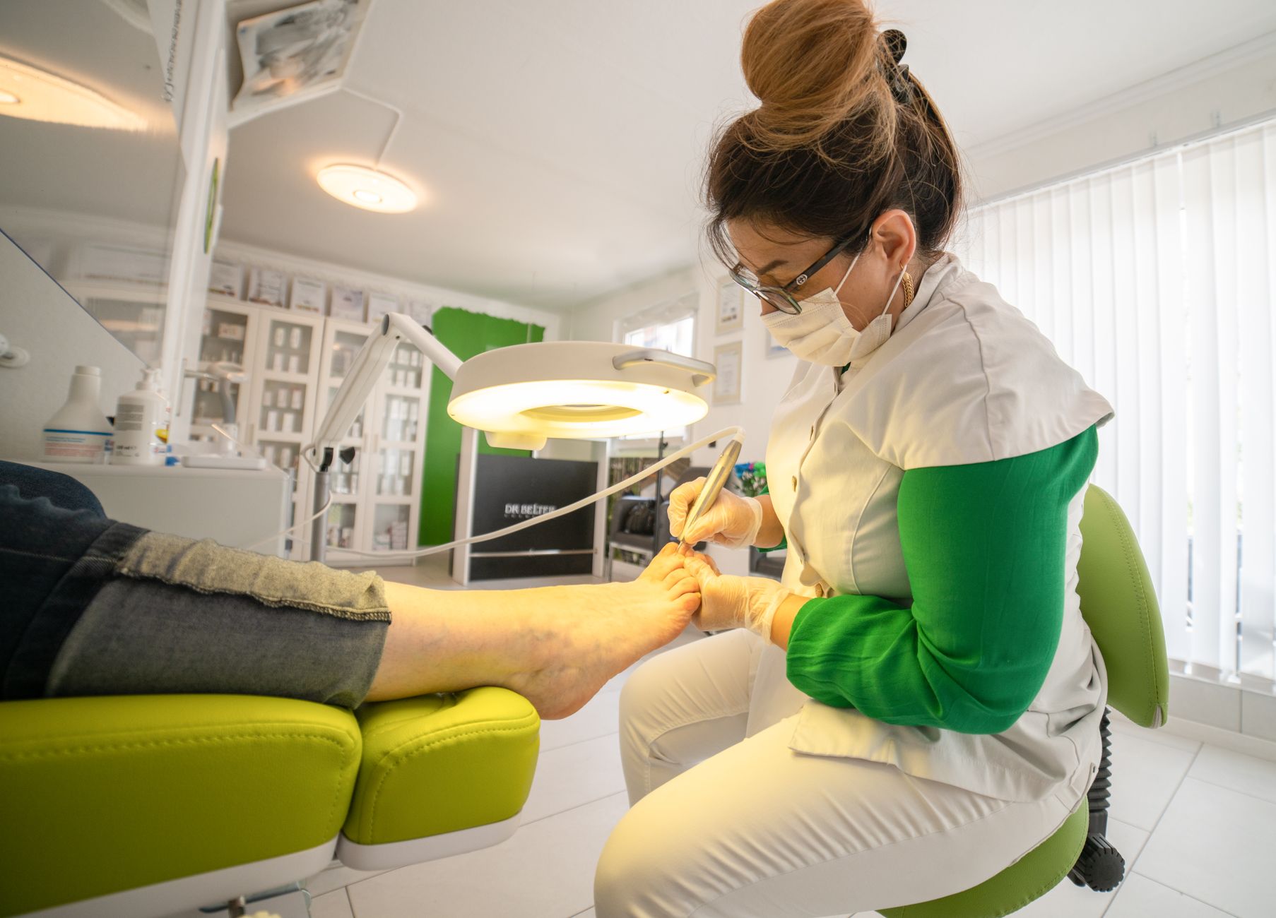 Focused woman doing procedure on foot of client
