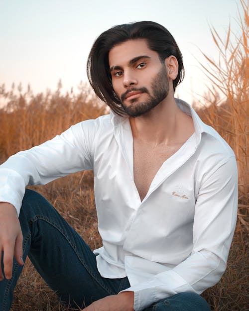 Handsome man sitting in countryside field