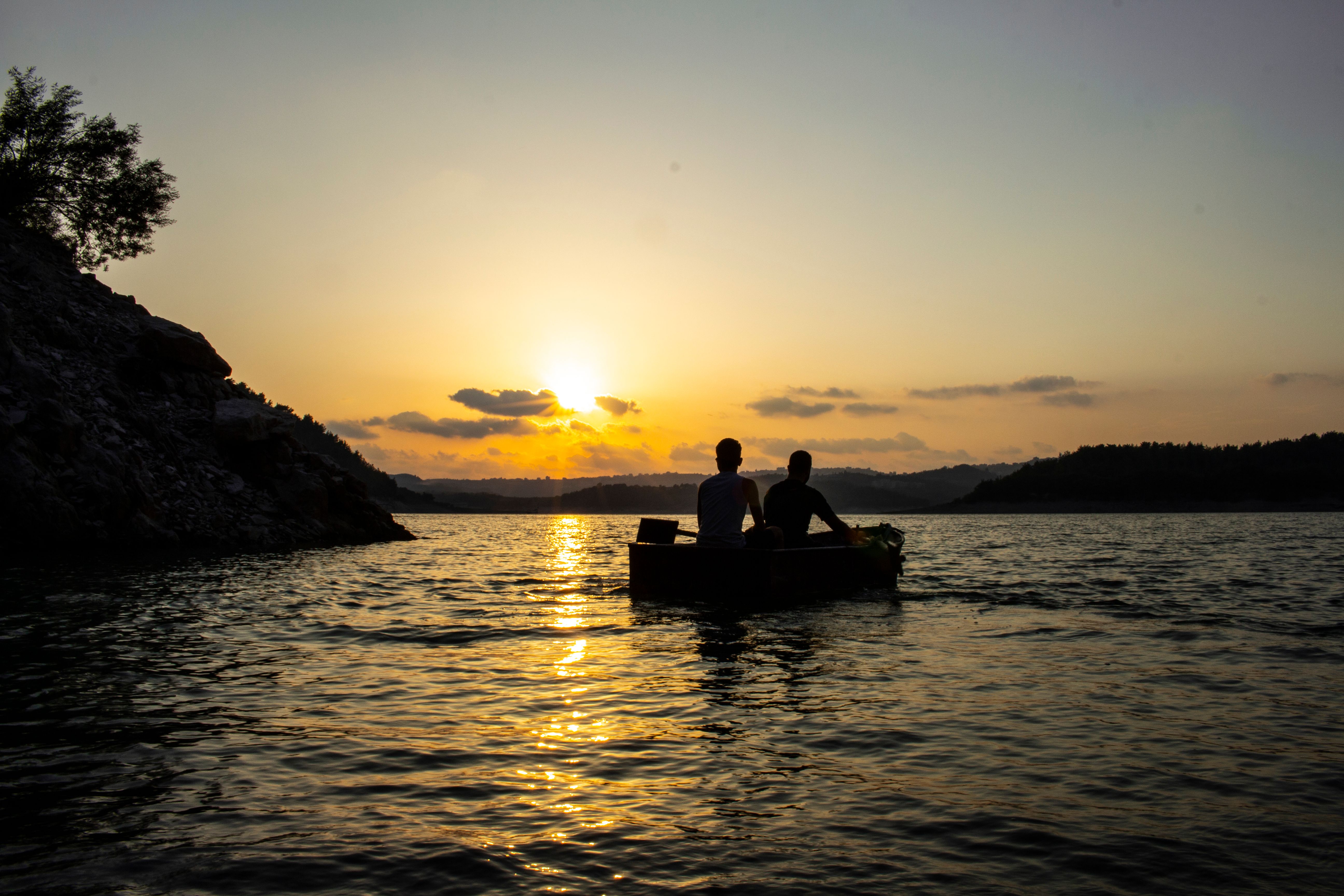 A Silhouette of People Riding on a Boat During Golden Hour · Free Stock ...
