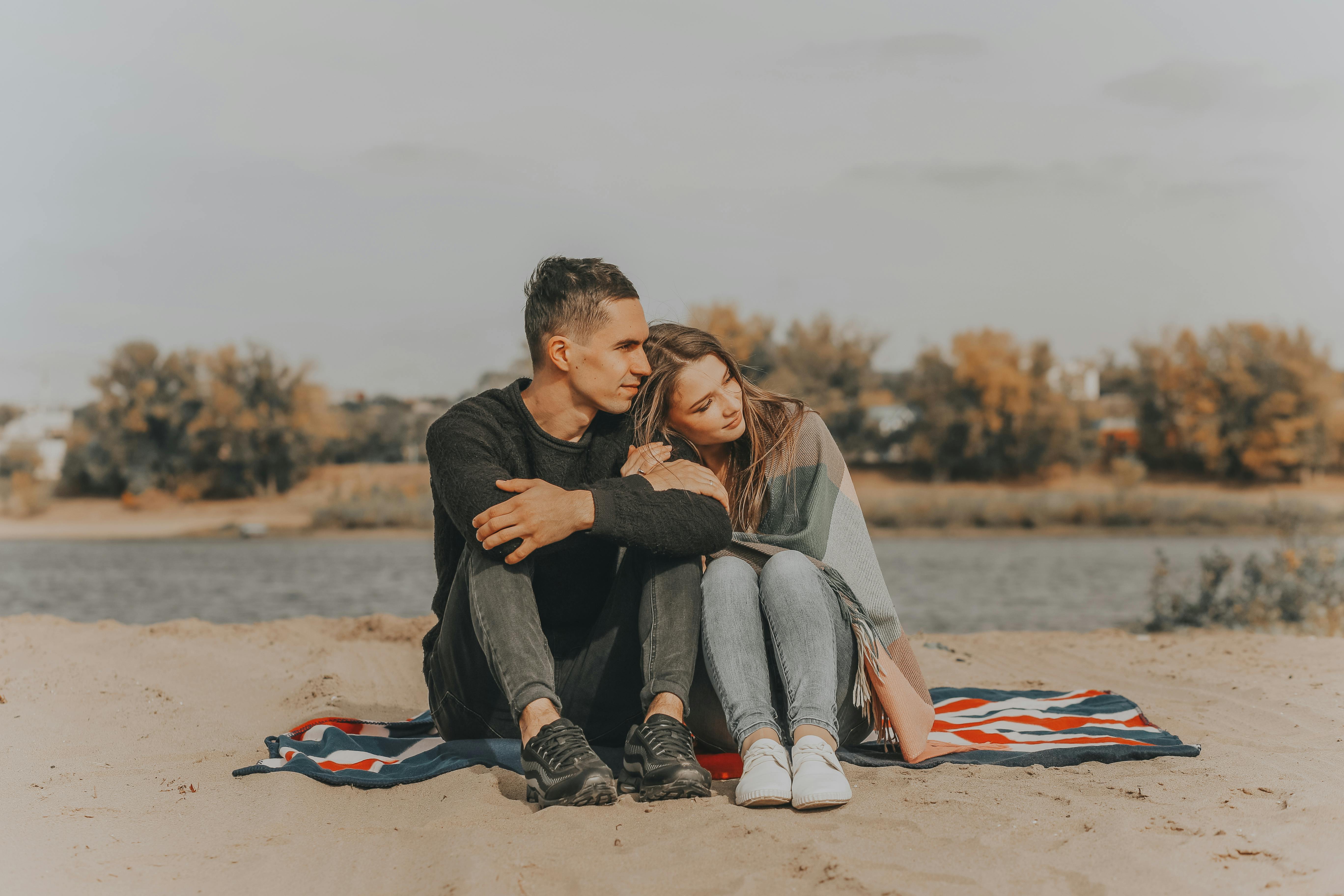 Romantic couple sitting on riverside · Free Stock Photo