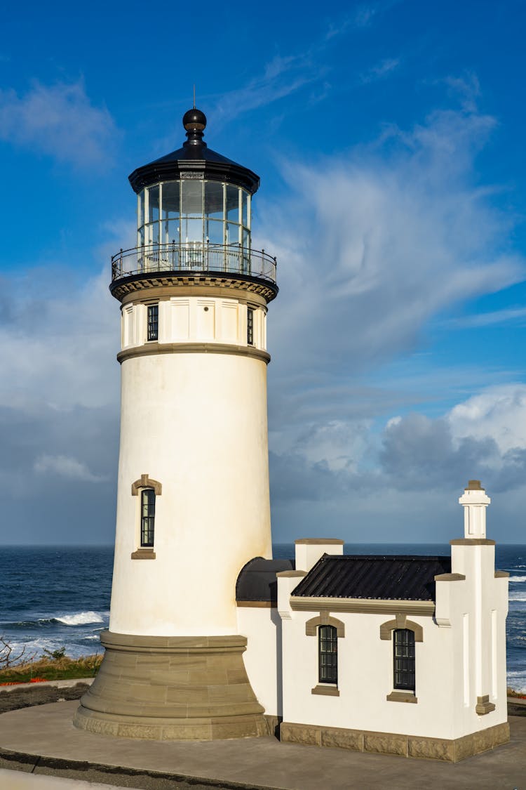 Cape Disappointment Lighthouse In Washington Under A Blue And Cloudy Sky