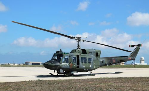 Free Military helicopter on runway in Luqa, Malta under clear sky. Stock Photo