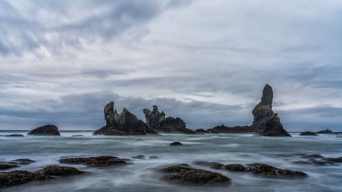 Free Beautiful seascape featuring dramatic rock formations under a cloudy sky, perfect for nature lovers. Stock Photo