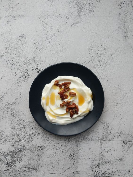 Free A mouthwatering plate of Greek yogurt topped with pecans and drizzled with honey. Stock Photo