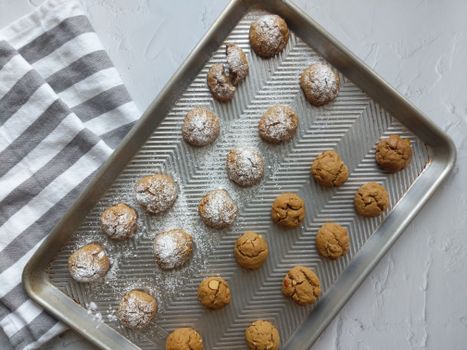A tray of homemade cookies dusted with powdered sugar, perfect for dessert lovers.
