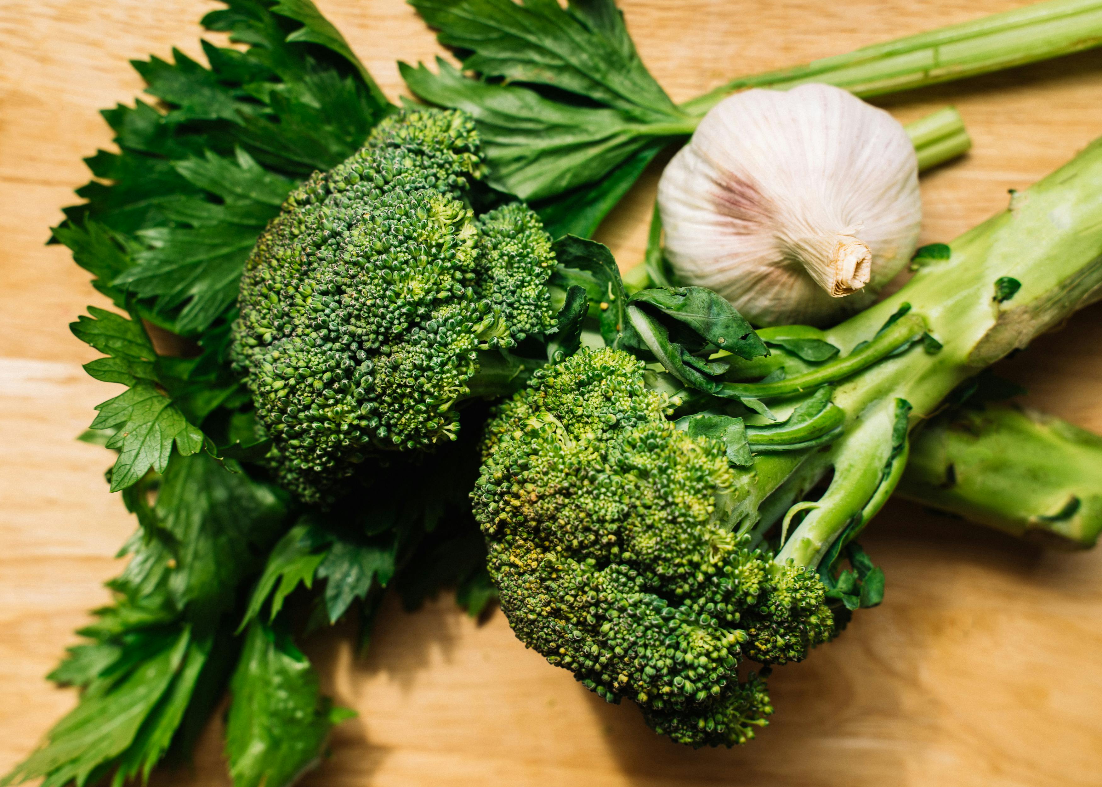 fresh broccoli ginger and garlic on a wooden cutting board - broccoli stir fry healthy