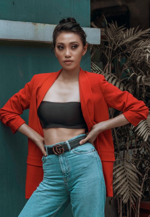 Free Fashionable woman in a red blazer and denim posing outside in Taguig, Philippines. Stock Photo