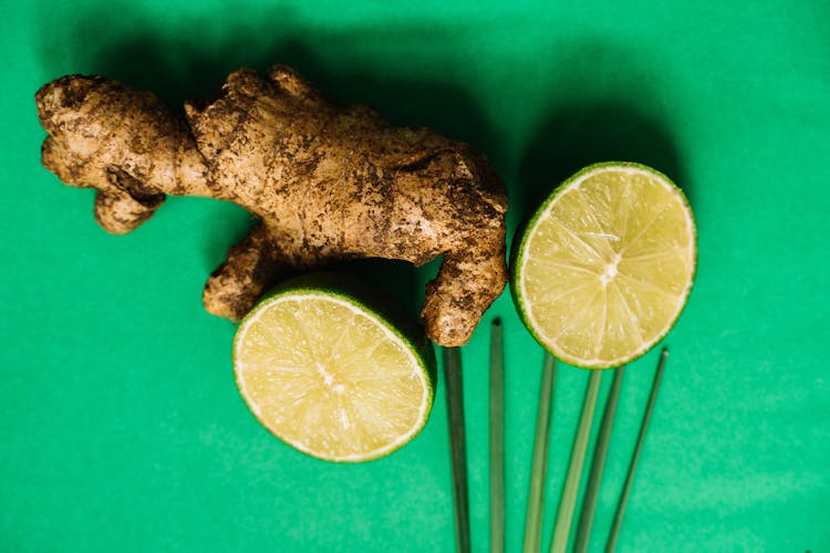  Ginger Root And Lime Halves On A Green Surface