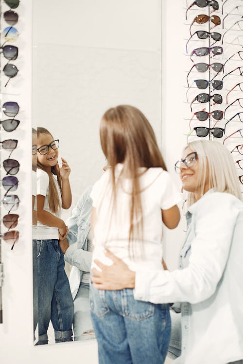 A Young Girl Looking at the Mirror while Wearing Eyeglasses