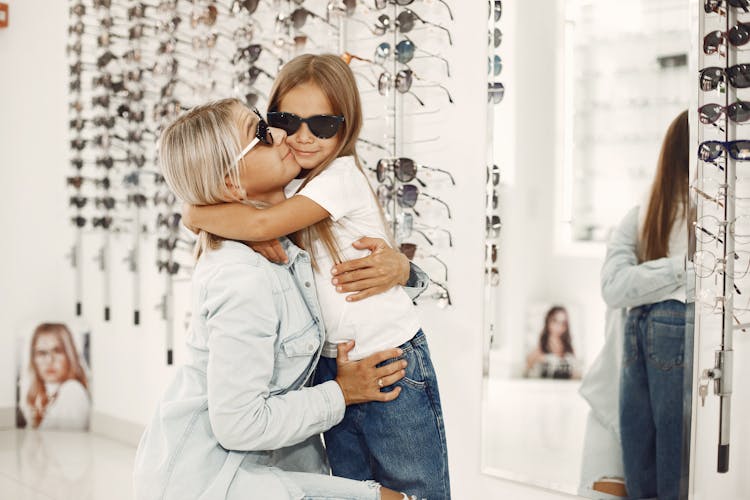 Mother And Daughter Choosing Sunglasses In An Optical Salon 