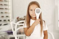 Girl Holding Item over Eye