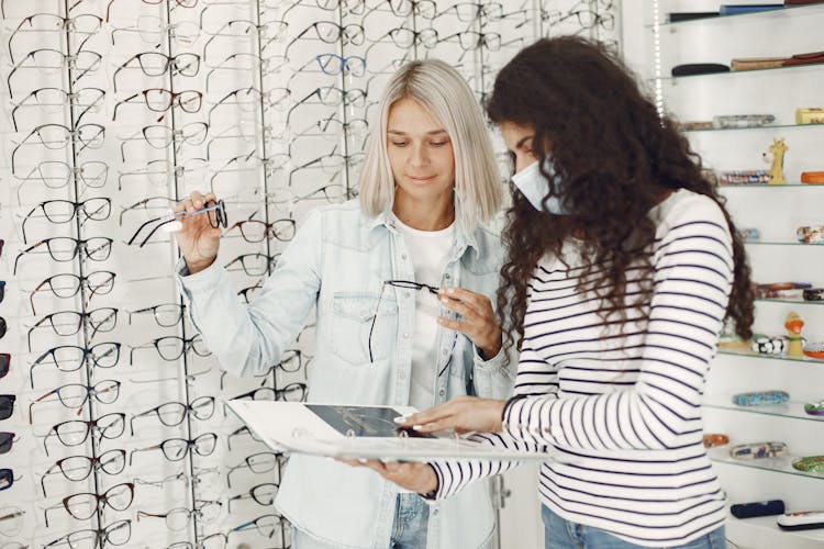 Women Choosing Glasses In An Optical Salon 