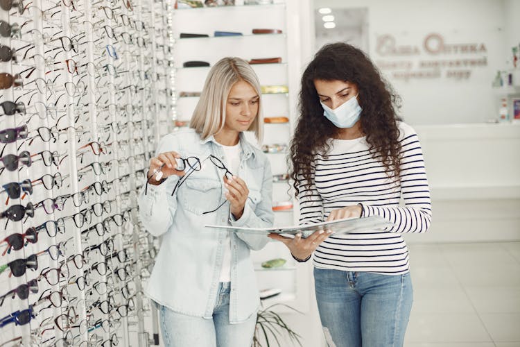 Woman Choosing Glasses At Optician Salon