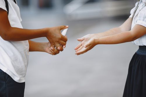 Free Close-up of hands sanitizing with a spray bottle, promoting hygiene and cleanliness. Stock Photo