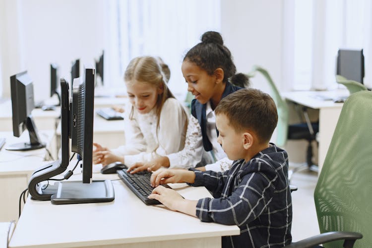 Kids In A Computer Lab Typing On A Keyboard 