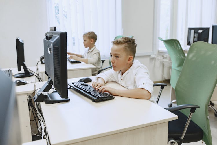 Boys Working On Computers In Classroom