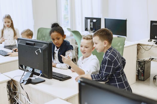 Young students engaging with computers in a modern classroom setting.
