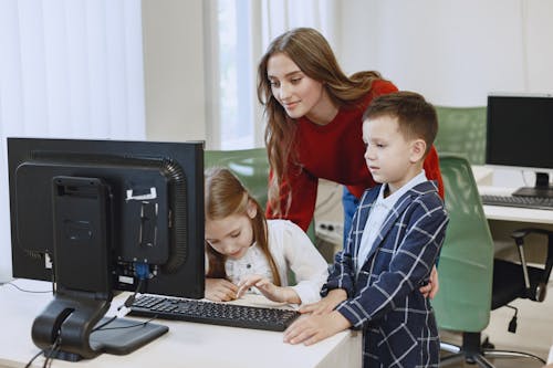 Free Teacher with Children Using Computer Stock Photo