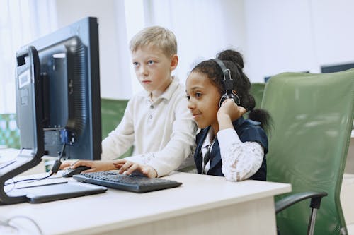 Boy and Girl Sitting in Front of a Computer 