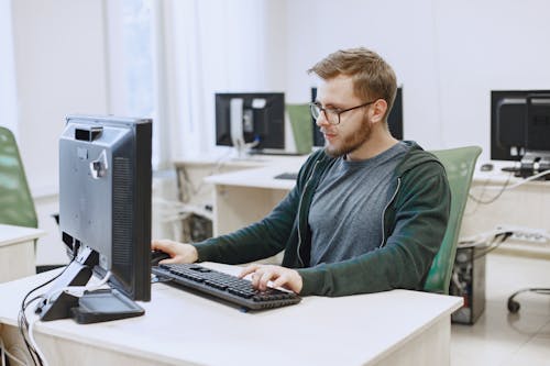A Man Wearing Eyeglasses while Looking at the Computer