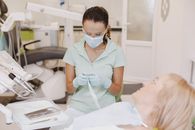 Dentist in mask preparing dental tools for patient in a modern office.
