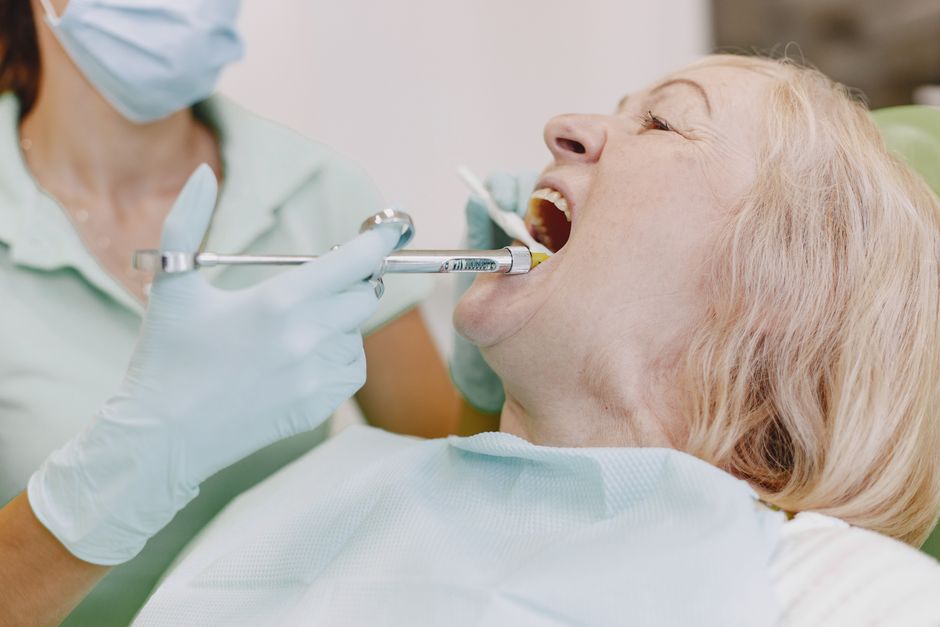 Applying dental sealant to a senior patient's molar - Florida senior sealant dentistry Applying dental sealant to a senior patient's molar - Florida senior sealant dentistry