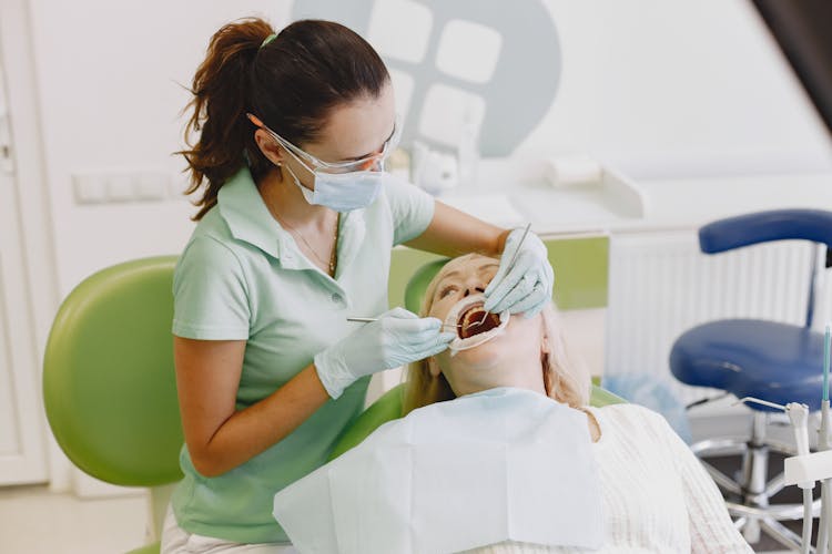 Dentist Curing Patient Teeth In Clinic