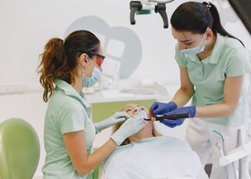 Dentists performing a dental procedure on a patient in a contemporary clinic.