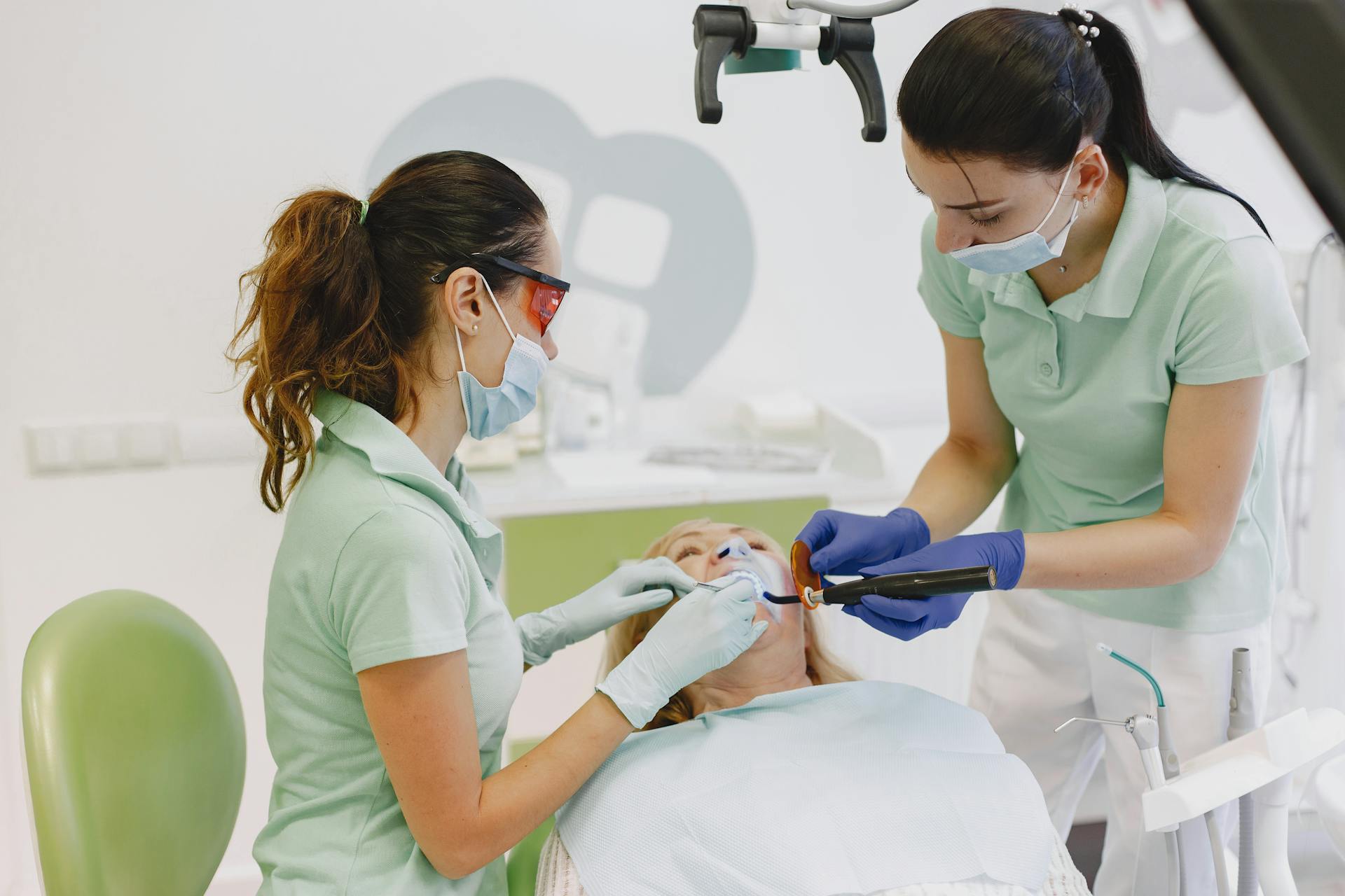 Dentists performing a dental procedure on a patient in a contemporary clinic.