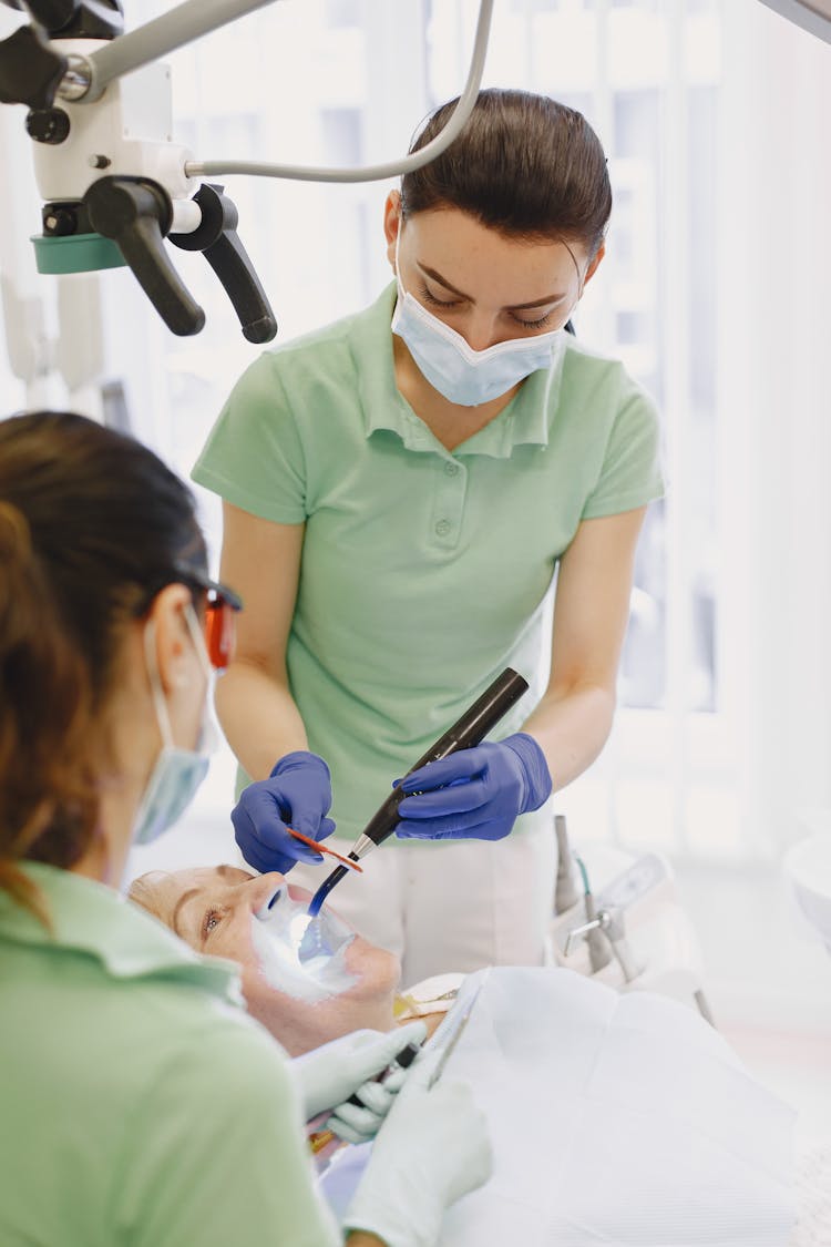 Dentist With Assistant And Patient In Office