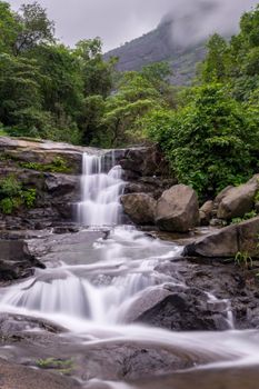在印度马哈拉施特拉邦风景优美的环境中，宁静的瀑布被郁郁葱葱的绿色植物所环绕