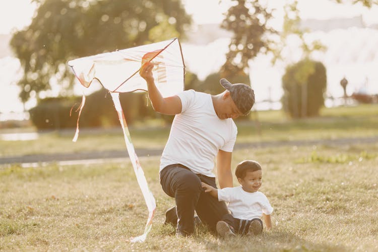 Father And Son In A Park Flying A Kite 