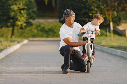 A Man Guiding His Son Riding a Bike